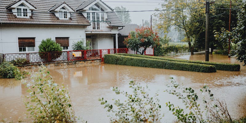 Water damage to residential ceiling and walls with visible staining and peeling paint